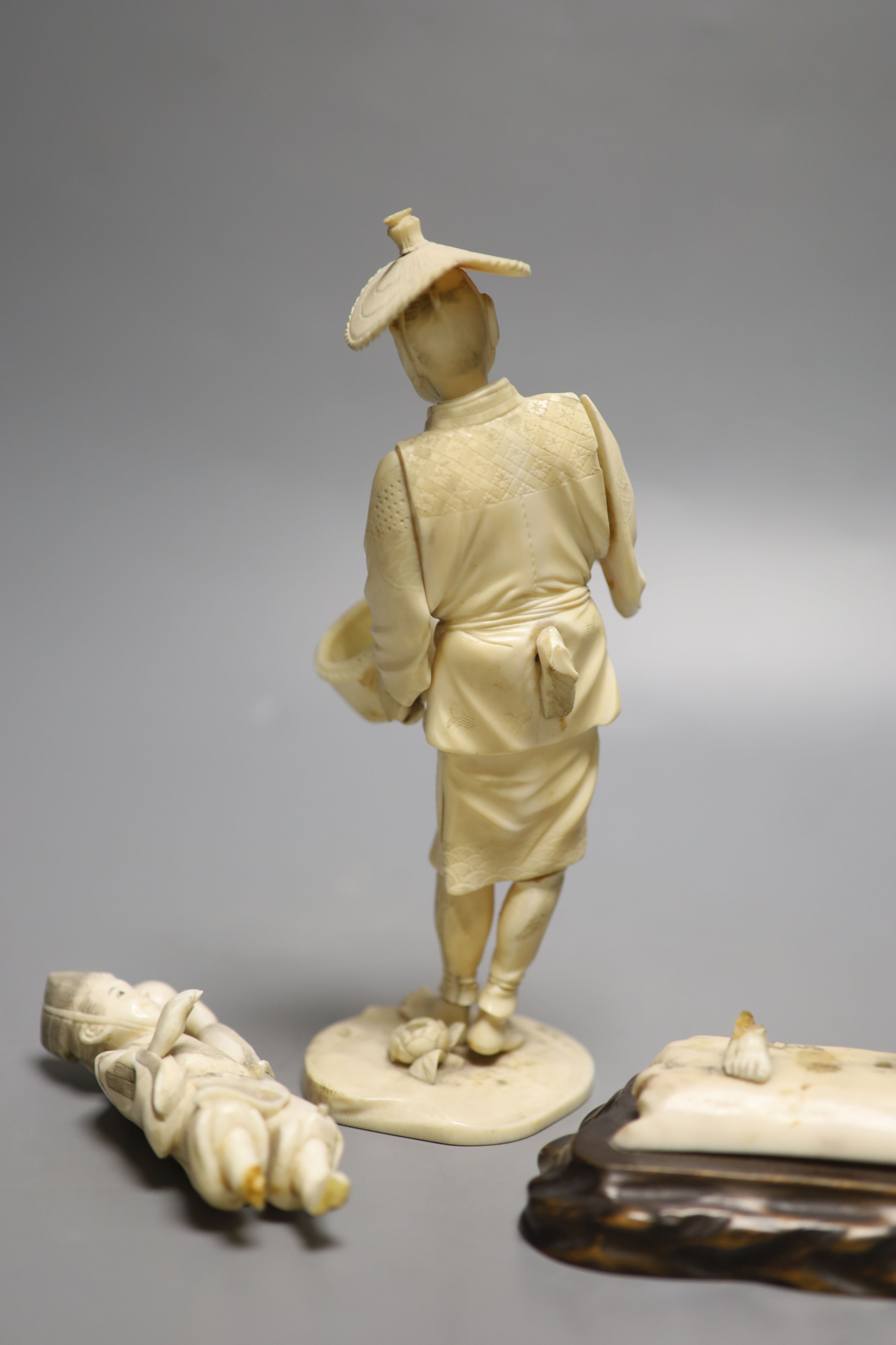 A Japanese Meiji period sectional carved ivory of a man, height 23cm and a Meiji ivory group (damaged)